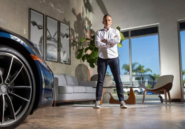 eMotoring founder Scott Gladstone in the showroom beside a blue Porsche